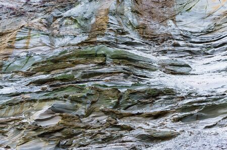 steep sea shore, clay overgrown slope, different soils on the collapsed rock