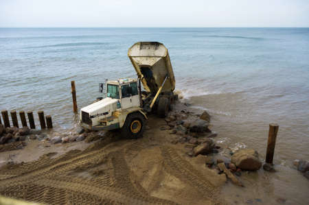 construction equipment on the shore, the construction of breakwaters, coastal protection measures, Baltic sea, Russia, Kaliningrad region, February 15, 2020のeditorial素材