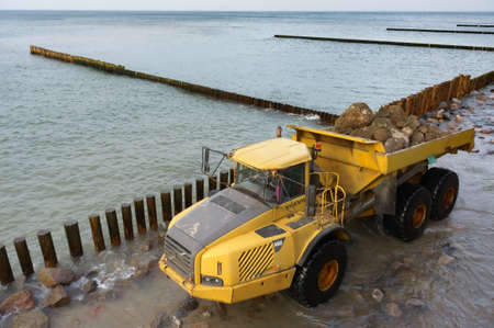 construction equipment on the shore, the construction of breakwaters, coastal protection measures, Baltic sea, Russia, Kaliningrad region, February 15, 2020のeditorial素材