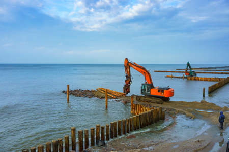 construction equipment on the shore, the construction of breakwaters, coastal protection measures, Baltic sea, Russia, Kaliningrad region, February 15, 2020のeditorial素材