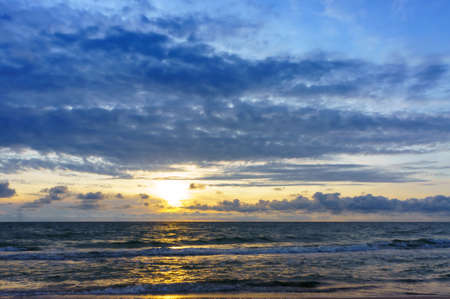 the sun going below the horizon of the sea, sunset on the sea coastの写真素材