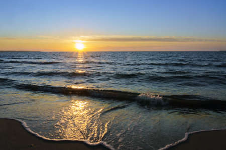 the sun going below the horizon of the sea, sunset on the sea coastの写真素材