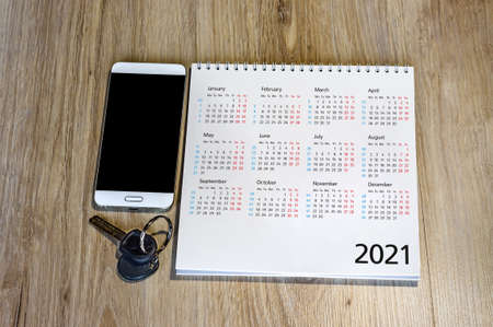 calendar for 2021 and keys on the table, white smartphone and calendar for 2021 (January, February, may, December)の写真素材