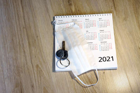white medical mask and calendar for 2021 (January, February, may, December), medical mask and keys on the tableの写真素材