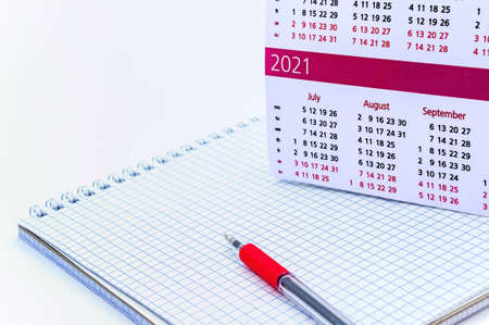 Notepad and calendar 2021, red pen and Notepad on a white backgroundの写真素材