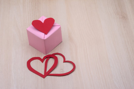gift in pink packaging, red hearts in honor of February 14, valentine's dayの写真素材