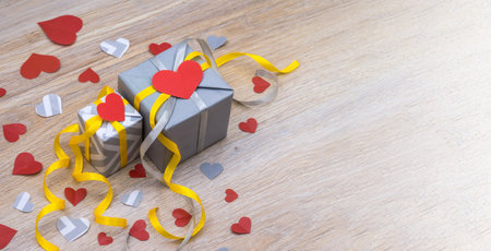 valentine's day decor, gray gift with yellow ribbon, gray packaging with red ribbon, valentine's day february 14の写真素材