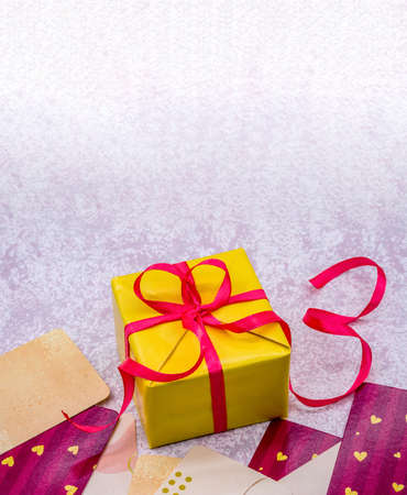 yellow gift with pink ribbons, gift wrap on pink background, Valentine's day February 14