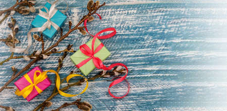 Willow twigs. Holy Easter. Blue turquoise background. Gift boxes with origami ribbons.