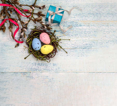 Happy Easter. Easter eggs in the nest. Willow twigs. Holy Easter. Blue turquoise background. Gift boxes with ribbons.の写真素材