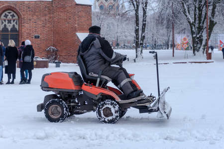 Kaliningrad, Russia, January 29, 2021. Snow removal equipment at work. A man cleans the roads from...