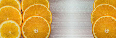 Oranges on a wooden background. Oranges cut into circles.の写真素材