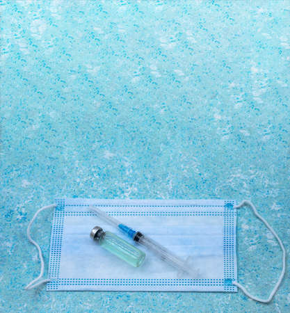 Medical instruments on blue background. Banner with medical items. Medical mask and vaccine. Ampoule of medicine and syringe.の写真素材