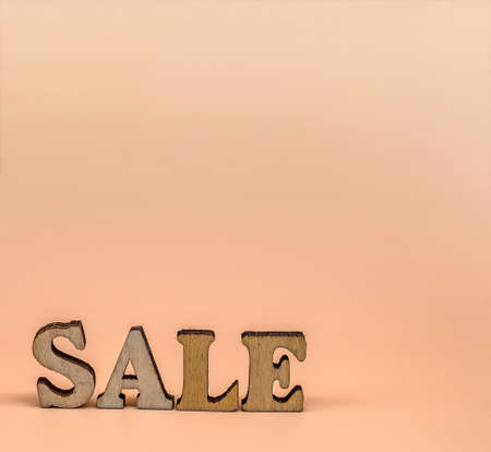 Discount sale. Large letters sale, action. Wooden letters discount on orange background.の写真素材