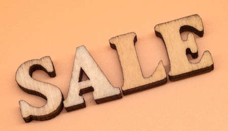 Discount sale. Large letters sale, action. Wooden letters discount on orange background.の写真素材