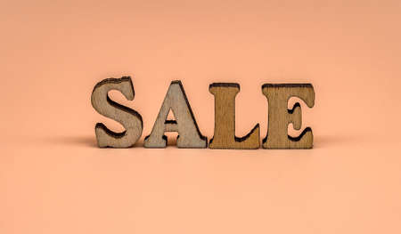 Discount sale. Large letters sale, action. Wooden letters discount on orange background.