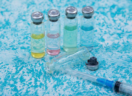 Prevention of seasonal diseases. Medical ampoules, syringes, and a mask on a green background.の写真素材