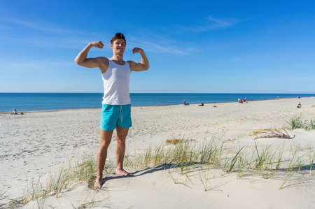 Kaliningrad region, Baltic Sea, Russia, May 10, 2020. Athletic build. Young man on the sea beach. Young man resting on the sea.のeditorial素材