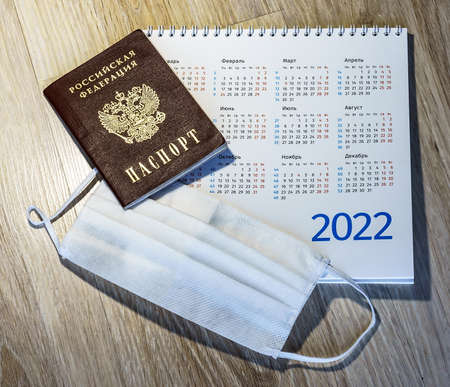Russian passport and calendar. Medical mask and calendar 2022. Sanitary mask and passport on the table.の写真素材