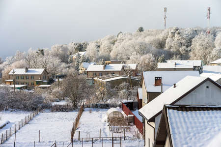 Kaliningrad region, Russia, January 30, 2021. New private homes. The village near the forest. Beautiful winter forest and roofs of the houses.のeditorial素材