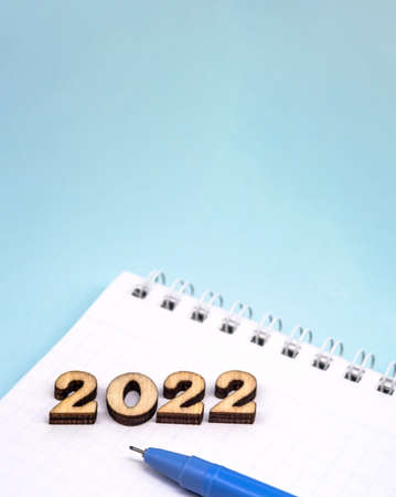Banner 2022 and notepad. Figures 2022 on blue background. Wooden figures on blue background. New...