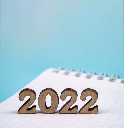 Banner 2022 and notepad. Figures 2022 on blue background. Wooden figures on blue background. New Year's calendar.の写真素材