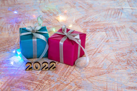 Wooden figures 2022 and garland. Gifts and figures 2022 on beige background. New Year's calendar.