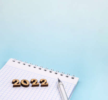 Banner 2022 and notepad. Figures 2022 on blue background. Wooden figures on blue background. New Year's calendar.の写真素材