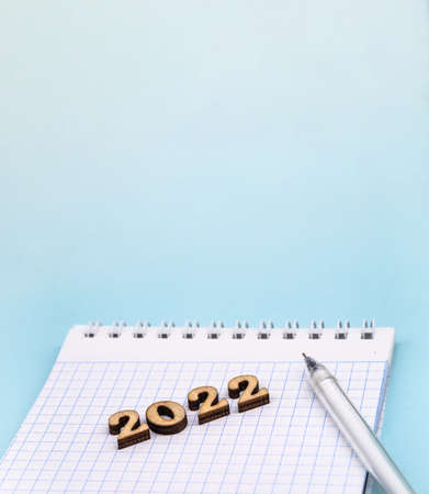 Banner 2022 and notepad. Figures 2022 on blue background. Wooden figures on blue background. New Year's calendar.の写真素材