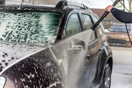 Kaliningrad, Russia, March 1, 2020. A man washes his car at a touchless car wash. Washing his brown Renault car. The SUV at the car wash.のeditorial素材