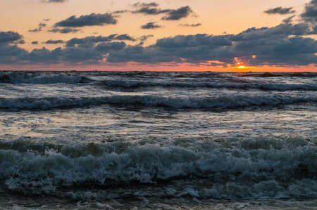 Sunset over the sea. Red and yellow sky in the rays of the sunset. Reflection of sunlight in the sea...