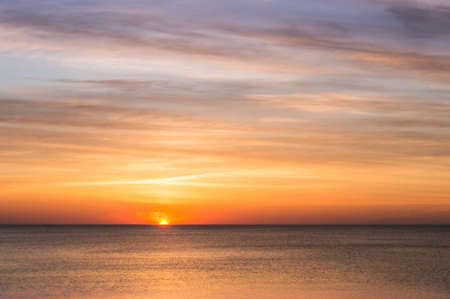 Reflection of sunlight in the sea waves. Red and yellow sky in the rays of the sunset. Sunset over the sea.の写真素材