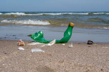 Pollution of the coast with plastic bottles. Garbage on the beach. Plastic on the beach. Green empty...
