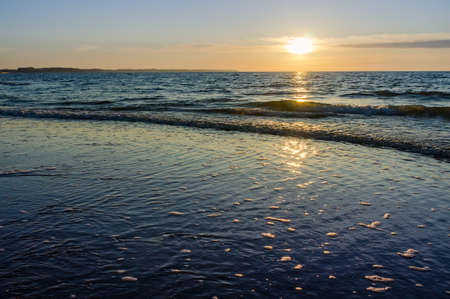 Sunset over the sea. Red and yellow sky in the rays of the sunset. Reflection of sunlight in the sea waves.の写真素材