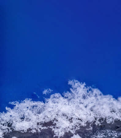 Snow on a large scale. Snowflakes on a blue background. Snow background. Verticalの写真素材
