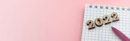 Wooden numbers 2022. Notepad on a spring. Notepad and Pen on Pink. Pink Pen. Spiral spiral checkered...