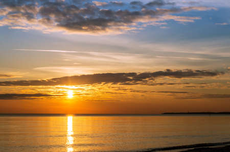 Reflection of sunlight in the sea waves. Sunset over the sea. The sky in the sunset rays.の写真素材