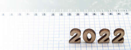 Wooden numbers date 2022. Notebook on the table. A blank sheet of paper.の写真素材