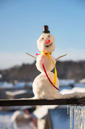 A snowman with a scarf. The snowman is small. A personage made of snow.の写真素材