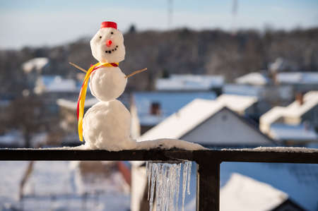 A snowman with a scarf. The snowman is small. A personage made of snow.の写真素材