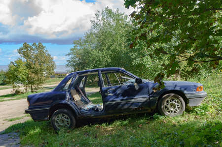 Kaliningrad region, Russia, September 4, 2021. Wrecked old car. Abandoned car. Stolen car. Mitsubishi blue. Passenger car.のeditorial素材