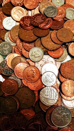 Closeup image of a pile of british coins rangin from one penny to 20 pence pieces.
