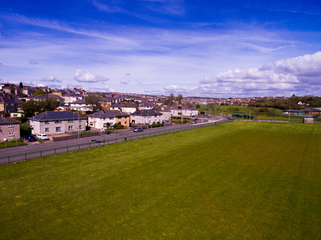 A large field with a row of houses across from it.の写真素材
