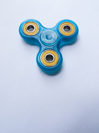 A blue fidget spinner isolated on a white background.の写真素材