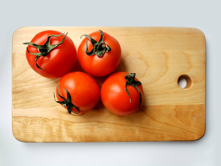 tomatoes on a wooden cutting board on a gray background, top viewの写真素材