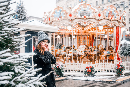 Beautiful russian girl in a cloud day in winter style clothes, walking in Tverskaya Square in Christmas timeの写真素材