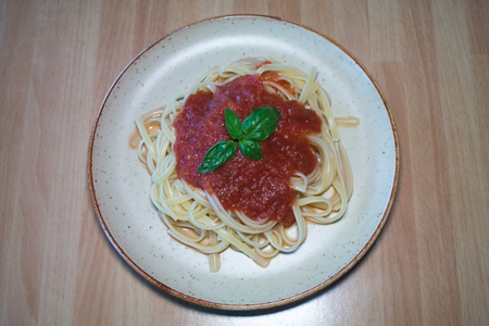 Linguine with tomato sauce on a wooden table viewed from aboveの写真素材