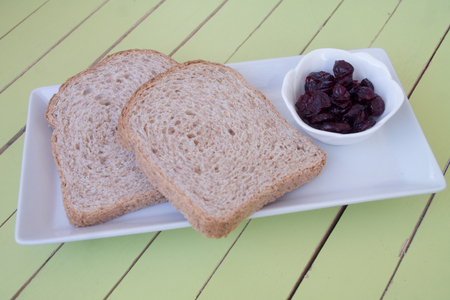 Sliced dried bread and blueberries on a green wooden tableの写真素材