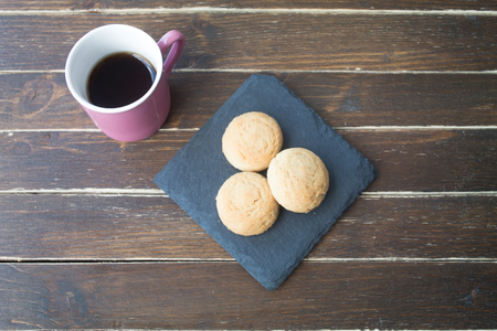 Cookies and coffee on a wooden table seen from aboveの写真素材