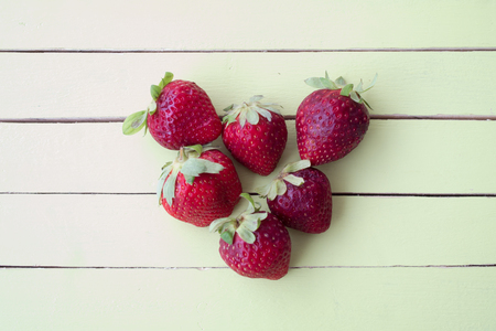 strawberries on a green wooden table viewed from aboveの写真素材